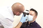 An optometrist using the breath shield